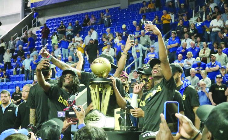 McNeese State University basketball players take selfies with the Southland Conference Basketball Championship trophy after defeating Nicholls State University, 92-76, on Wednesday, March 13. (Gazette photo by Tony Marks)